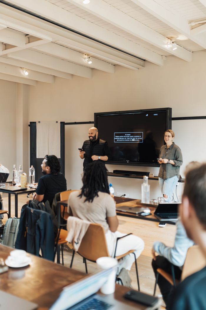 A group of adults attending a business presentation in a contemporary office space.